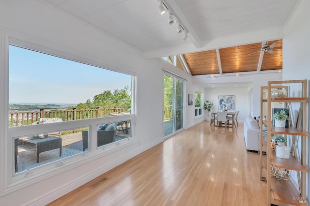 sunroom featuring track lighting, ceiling fan, lofted ceiling with beams, and wooden ceiling