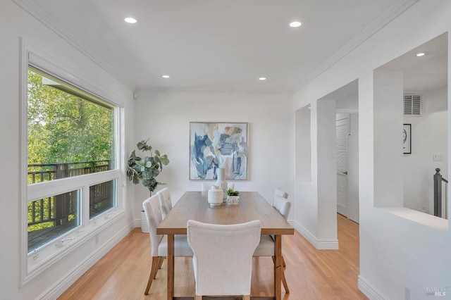 dining area featuring ornamental molding, a healthy amount of sunlight, and light hardwood / wood-style flooring