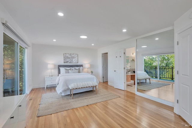 bedroom with light wood-type flooring, multiple windows, and access to outside