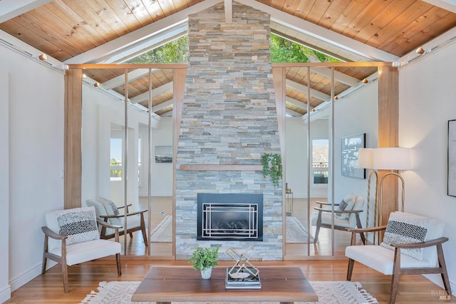 living room with lofted ceiling with beams, a healthy amount of sunlight, and wood ceiling