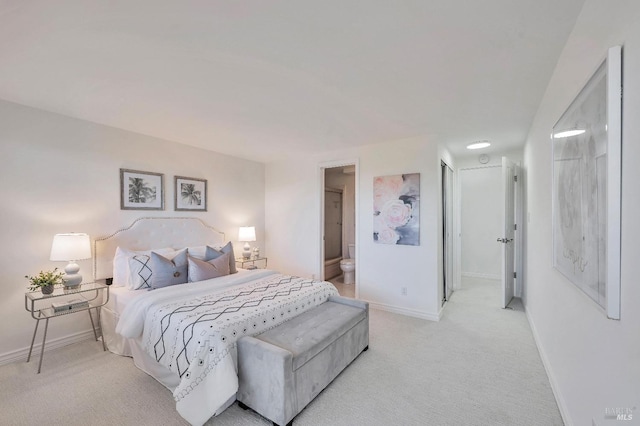 bedroom featuring ensuite bath and light colored carpet