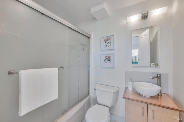 full bathroom featuring vanity, toilet, and bath / shower combo with glass door