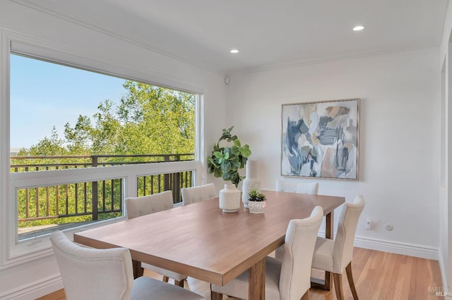 dining space with plenty of natural light, ornamental molding, and light hardwood / wood-style floors