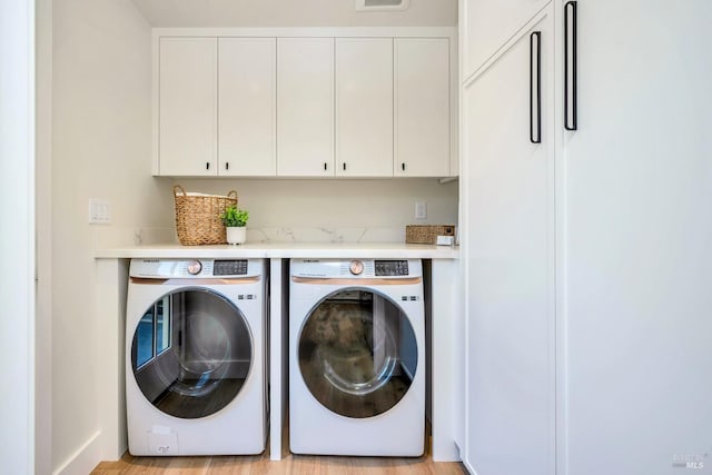 washroom with washing machine and dryer, cabinet space, and visible vents