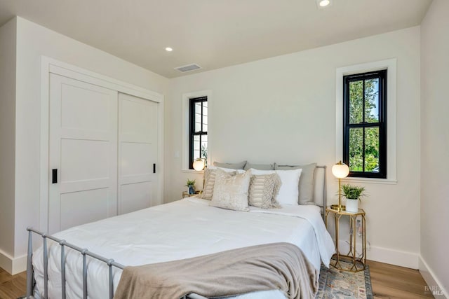 bedroom featuring recessed lighting, light wood-type flooring, visible vents, and baseboards