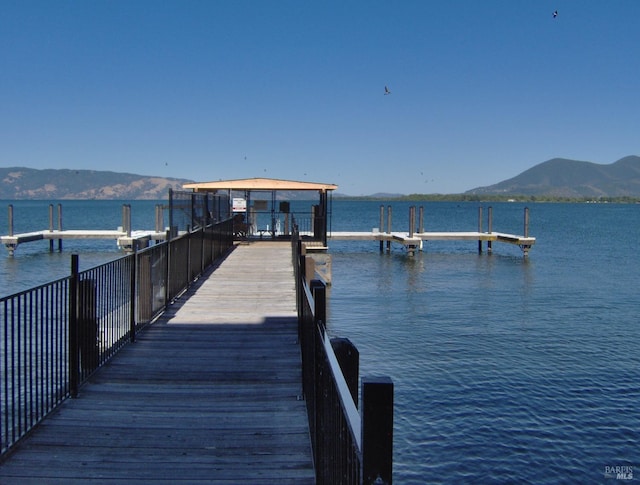 view of dock with a water and mountain view