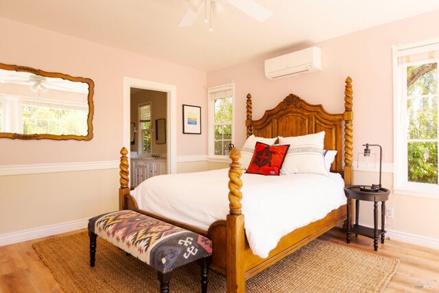 bedroom featuring wood-type flooring, a wall unit AC, and ceiling fan