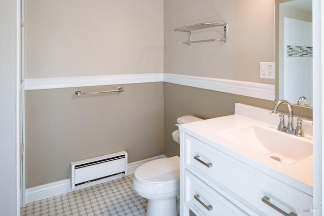 bathroom with walk in shower, vanity, baseboard heating, and toilet