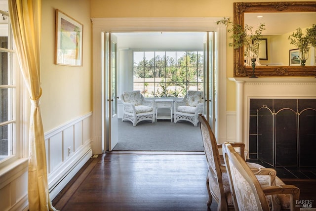 interior space featuring hardwood / wood-style flooring, baseboard heating, and a healthy amount of sunlight