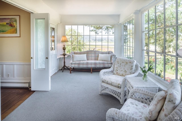 sunroom featuring a baseboard heating unit and plenty of natural light