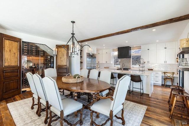 dining room featuring a notable chandelier, dark hardwood / wood-style flooring, beamed ceiling, and sink