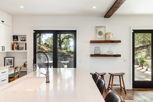 dining area with beamed ceiling, wood finished floors, and recessed lighting