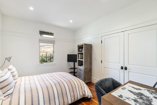 bedroom with recessed lighting, dark wood finished floors, and a closet
