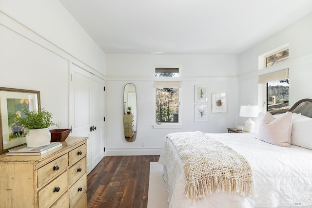 bedroom featuring baseboards and dark wood-style floors
