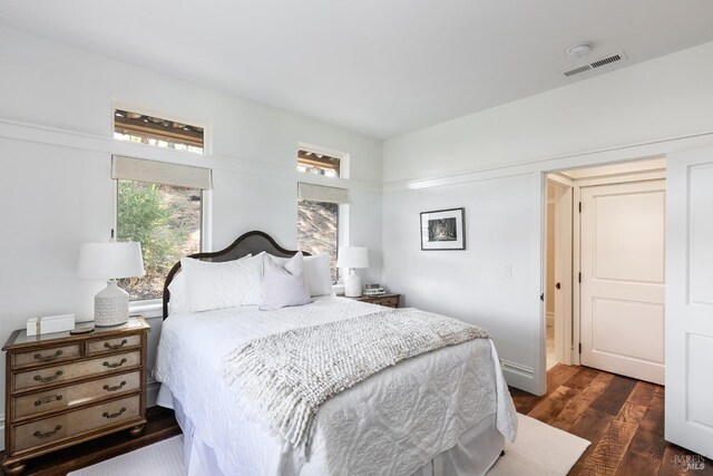 bedroom with dark hardwood / wood-style flooring