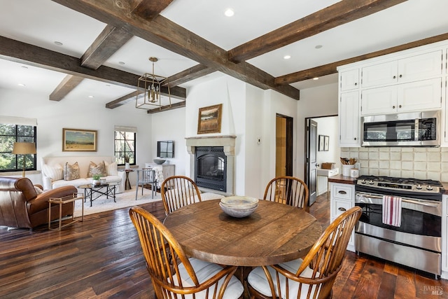 dining area featuring a glass covered fireplace, dark wood-type flooring, beamed ceiling, and recessed lighting