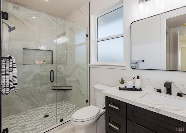 bathroom with walk in shower, vanity, and toilet