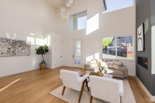 living room featuring a high ceiling and light wood-type flooring