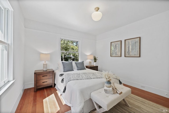 bedroom featuring wood finished floors and baseboards