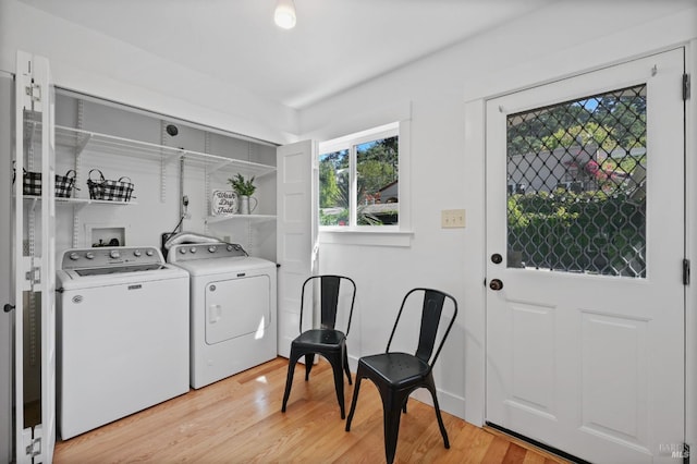 laundry area with separate washer and dryer and light hardwood / wood-style floors