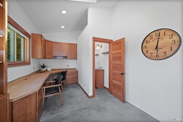 home office with built in desk and concrete floors