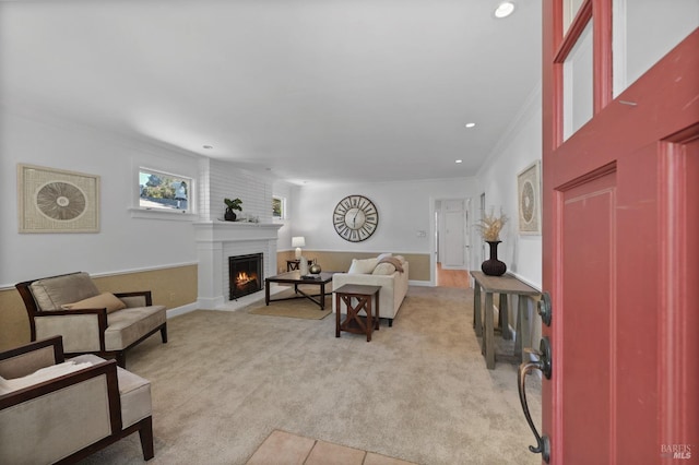 living room featuring crown molding, light carpet, and a fireplace