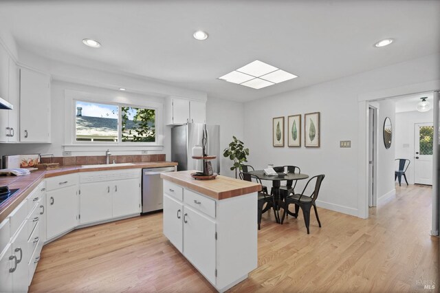 kitchen featuring light hardwood / wood-style flooring, white cabinets, appliances with stainless steel finishes, and sink