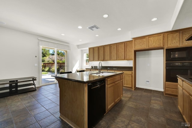 kitchen featuring black appliances, sink, and a center island with sink