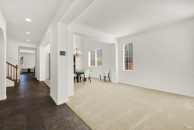 interior space with dark carpet and a chandelier