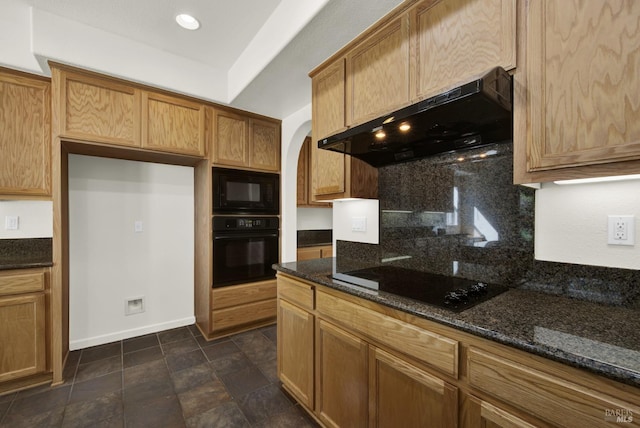 kitchen featuring black appliances, dark stone countertops, and extractor fan