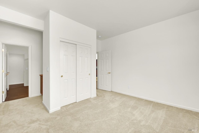 unfurnished bedroom with a closet and light carpet