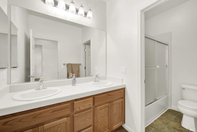 full bathroom with tile patterned flooring, toilet, combined bath / shower with glass door, and vanity