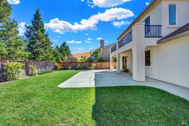 view of yard featuring a balcony and a patio