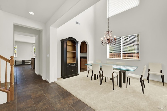 carpeted dining area featuring a chandelier