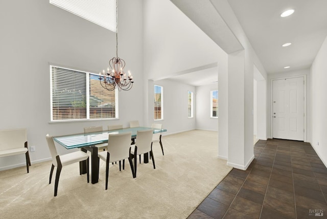 dining area featuring a healthy amount of sunlight, a high ceiling, a notable chandelier, and carpet