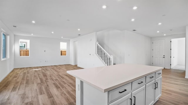 kitchen featuring light wood-type flooring, a kitchen island, and white cabinets