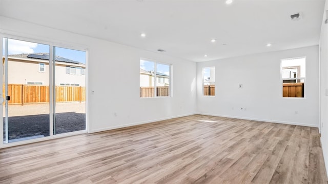 empty room with light wood-type flooring and plenty of natural light