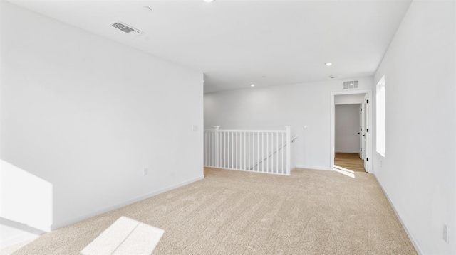 spare room featuring light colored carpet