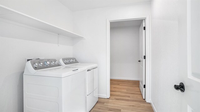 laundry room with independent washer and dryer and light hardwood / wood-style floors