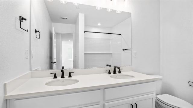 bathroom with vanity, a shower, and toilet