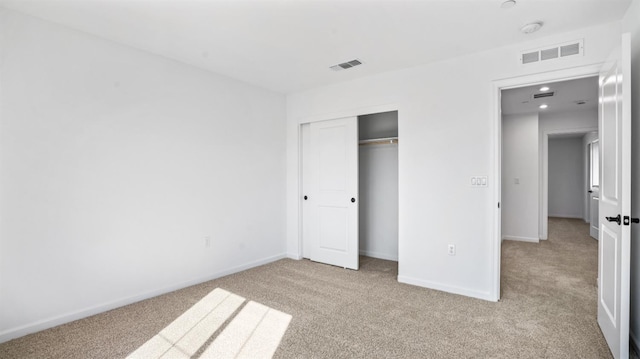 unfurnished bedroom with a closet and light colored carpet