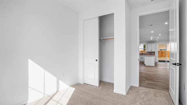 unfurnished bedroom featuring light colored carpet and a closet