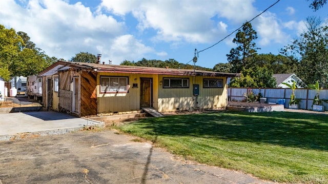 ranch-style house featuring a front yard and fence