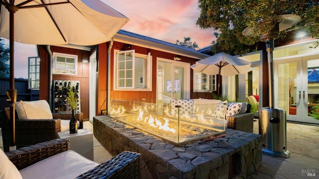 patio terrace at dusk featuring an outdoor fire pit