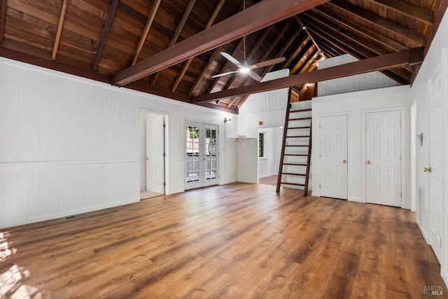 unfurnished living room featuring vaulted ceiling with beams, wood-type flooring, wooden ceiling, and french doors