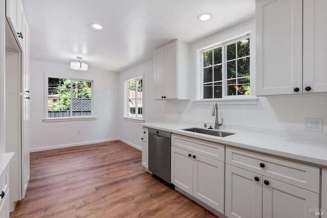 kitchen featuring sink, wood-type flooring, white cabinets, and dishwasher