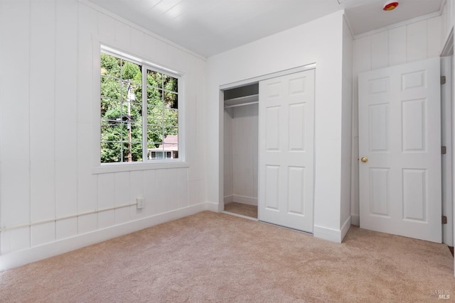 unfurnished bedroom featuring a closet and light carpet