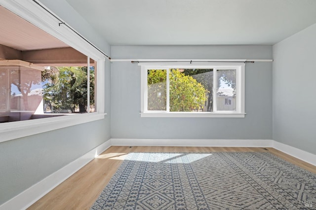 empty room with baseboards and wood finished floors