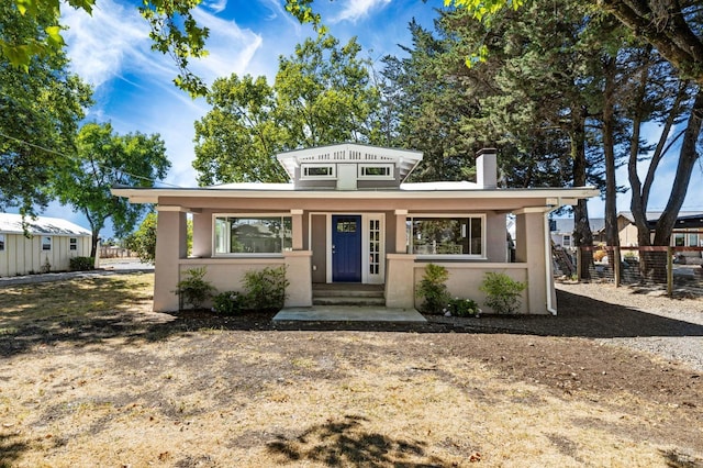 view of front of house with stucco siding and fence