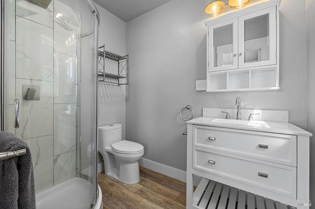full bathroom with vanity, a marble finish shower, toilet, baseboards, and wood finished floors